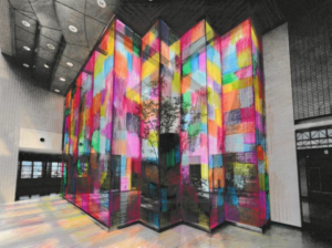 大川友希による、「いんざいの不思議な庭」展示風景のイメージドローイング。文化ホールの中庭に面したガラスの壁に、薄く透ける布のパッチワークが掛かっている。